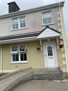 Casa amarilla con puerta blanca y ventanas en harmony house, en Letterkenny