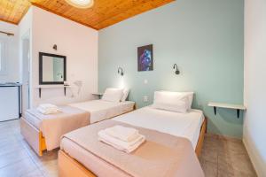 a room with two beds and a mirror at Saint Peter Bay Aparthotel in Kavos