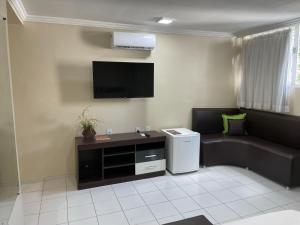a living room with a couch and a flat screen tv at Hotel Piramide St. Antonio de Jesus in Santo Antônio de Jesus