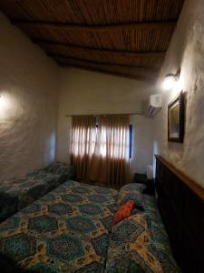 a bedroom with two beds and a window with curtains at Encantadora Villa Aquarine in Buena Vista