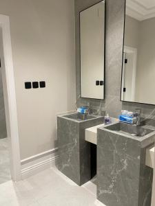 a bathroom with two sinks and a mirror at فيلا عطر الهدا in Al Hada +19 photos