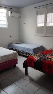 a bedroom with two beds and two windows at Casa Mosqueiro in Mosqueiro +18 photos