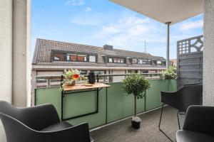 un balcone con tavolo e sedie su un edificio di BLICKFANG - zentrale Ferienwohnung im Herzen von Friedrichshafen a Friedrichshafen