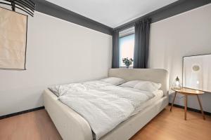 una camera bianca con un letto in una stanza di BLICKFANG - zentrale Ferienwohnung im Herzen von Friedrichshafen a Friedrichshafen