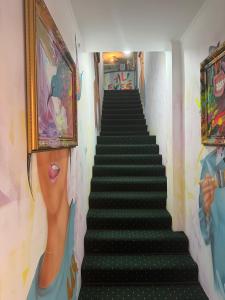 una scala in una stanza con un dipinto sul muro di All Eyes Hostel a Kam"janec'-Podil's'kyj