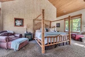 a bedroom with a wooden bed and a couch at Sundance Splendor- 5-Bed Cabin Oasis with Majestic Mountain Views in Sundance