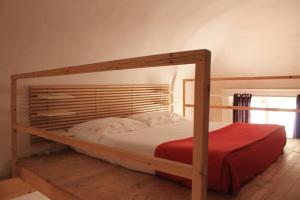 een slaapkamer met een houten stapelbed met een rode deken bij Casa Carolina in Giarre