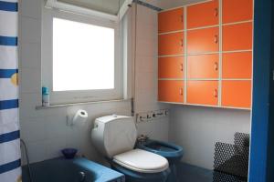 een badkamer met toilet, wastafel en raam bij Casa Carolina in Giarre