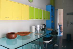 een keuken met gele kasten en een glazen aanrechtblad bij Casa Carolina in Giarre +25 foto's