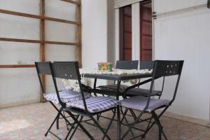 een zwarte tafel met vier stoelen en een tafel met bij Casa Carolina in Giarre