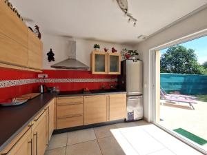 a kitchen with red walls and a stainless steel refrigerator at Modern House in Brittany near La Baule Bay in Pénestin +17 photos