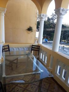 een glazen tafel en stoelen in een kamer met kolommen bij Ufuk Hotel in Sao Paulo +13 foto's