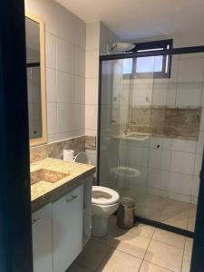 une salle de bain avec toilettes et douche en verre dans l'établissement Apartamento em Aquaville Resort, à Aquiraz