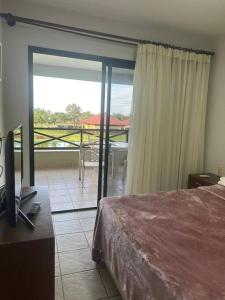 une chambre avec un lit et une vue sur un balcon dans l'établissement Apartamento em Aquaville Resort, à Aquiraz