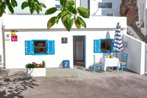 El PrisにあるLa Casa De Sandalioの青い窓とテーブルのある白い建物