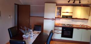 eine Küche mit Tisch und Stühlen und eine Küche mit Spüle in der Unterkunft Apartment in Pula 33579 in Loborika