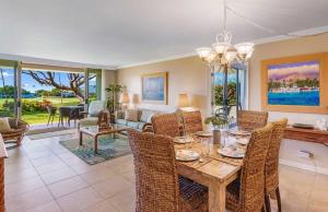 a dining room with a table and chairs and a living room at Maui Eldorado - L-105 - in Kahana