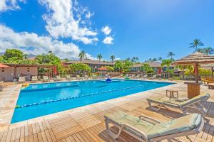 a swimming pool with chaise lounges and umbrellas at Maui Eldorado - L-105 - in Kahana