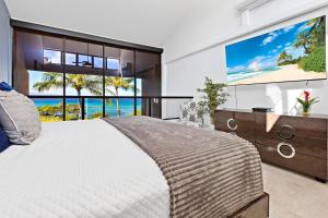a bedroom with a large bed and a large screen tv at Kahana Villas - F508 - in Kahana