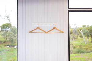 a wooden hanger hanging on the side of a building at McCabe Farm Cabin by Tiny Away in Brookton +16 photos