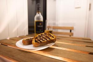 a bottle of wine and two pieces of bread on a table at McCabe Farm Cabin by Tiny Away in Brookton