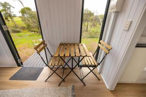 a wooden table and two chairs on a porch at McCabe Farm Cabin by Tiny Away in Brookton