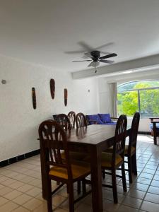 a dining room table with chairs and a ceiling fan at Casa Milo Isla Mujeres in Isla Mujeres