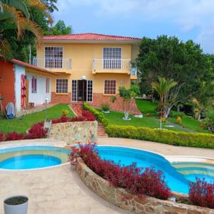 a house with two pools in front of a yard at Finca Hotel el Amanecer in Quimbaya