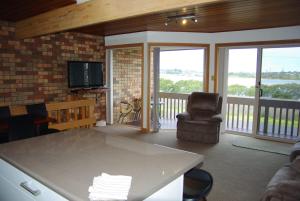 バーマグイにある3-6 Marina Townhouseのテーブルと椅子とテレビのあるリビングルーム