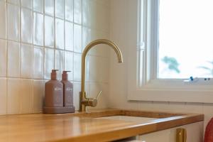 a kitchen sink with two bottles on the counter at 39 Scenic Drive in Bermagui +30 photos