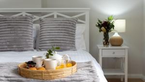 a basket of fruit on a bed with two pillows at Elliniko in Callala Beach