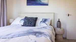 Un dormitorio con una cama con una almohada encima. en 54 Bunga Street, en Bermagui