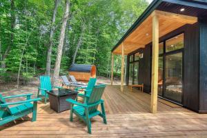 a wooden deck with chairs and a house at Valhalla Tremblant Cabin Retreat-Your Haven Awaits! in La Conception