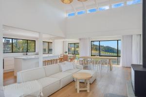 een woonkamer met een witte bank en een tafel bij 35 Scenic Drive in Bermagui