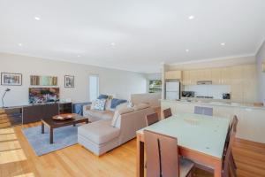 a kitchen and living room with a table and a couch at Seascape 3-7 in Bermagui