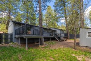 a house with a deck and a tree at Wooded Oasis, Hot Tub, Fenced Yard, Chic Design in Mountainaire