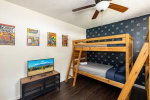 a bedroom with a bunk bed and a flat screen tv at Wooded Oasis, Hot Tub, Fenced Yard, Chic Design in Mountainaire