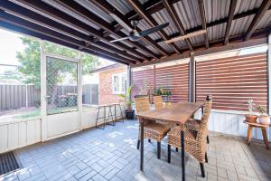 eine Terrasse mit einem Holztisch und Stühlen in der Unterkunft Rosewood Cottage - Stroll to Central, Cosy Escape in Dubbo