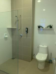 a bathroom with a toilet and a glass shower stall at Summer Villa Batu Ferringhi in Tanjung Bungah