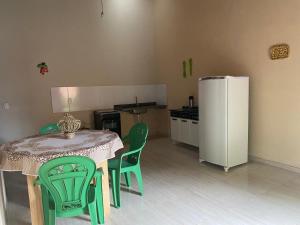 a kitchen with a table and chairs and a refrigerator at Casa da Andrea in Barreirinhas