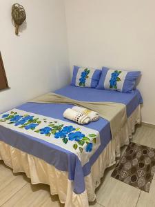a bedroom with a bed with blue and white sheets at Casa da Andrea in Barreirinhas