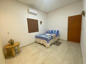 a room with a bed and a table in it at Casa da Andrea in Barreirinhas