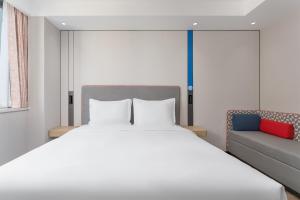 a bedroom with a large bed and a couch at Holiday Inn Express Xi'an Daxing by IHG in Xi'an