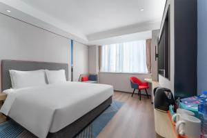 a hotel room with a white bed and a red chair at Holiday Inn Express Xi'an Daxing by IHG in Xi'an