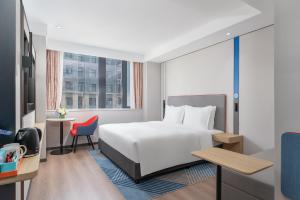 a hotel room with a bed and a desk at Holiday Inn Express Xi'an Daxing by IHG in Xi'an
