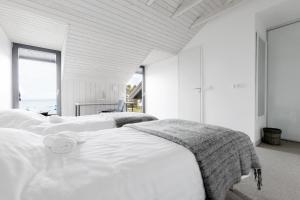 a bedroom with three beds with white sheets at Kalaranna Holiday Home in Eisma