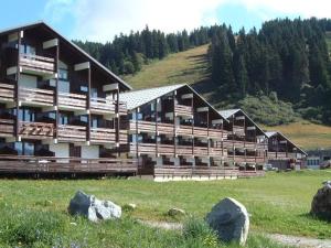 a large building in a field with rocks in front of it at Studio cabine rénové 4 pers avec garage, Les Saisies - FR-1-293-180 in Les Saisies +11 photos