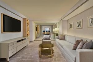 a living room with a couch and a tv at Sheraton Imperial Kuala Lumpur Hotel in Kuala Lumpur