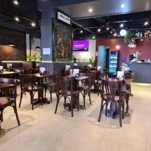 a restaurant with wooden tables and chairs in a room at Lindo Apto Flat Aconchegante e Mobiliado em Campinas !!! in Campinas