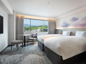 a hotel room with two beds and a desk and a window at Grand Mercure Nara Kashihara in Kashihara +98 photos